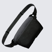 A navy blue Bellroy Venture Sling 9L with a black shoulder strap, main compartment, and a front zip pocket, designed for all-day adventure and organization.