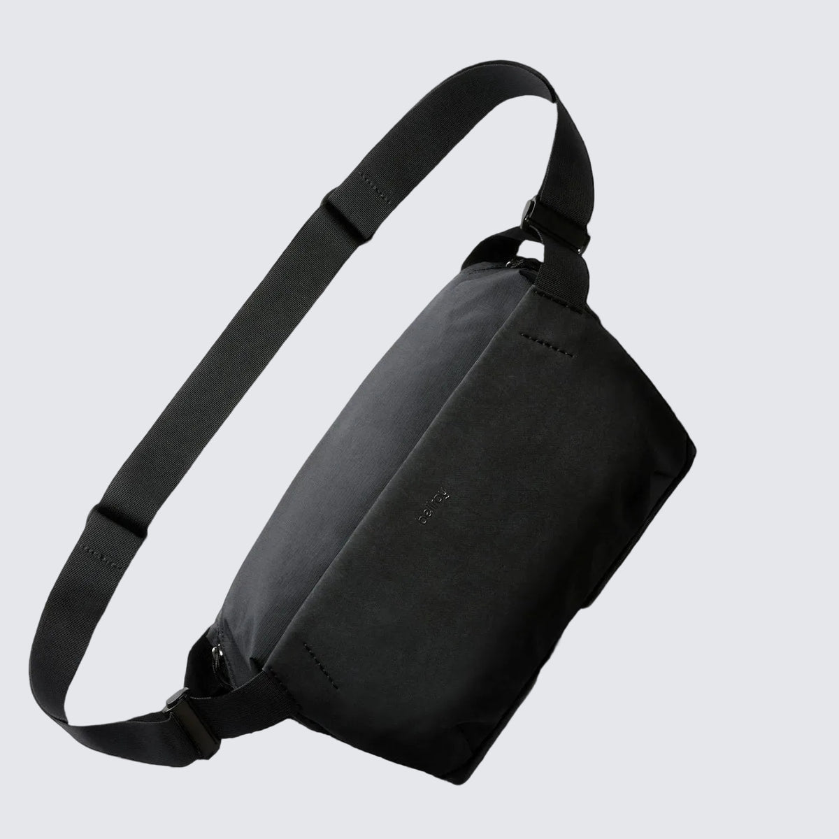 A navy blue Bellroy Venture Sling 9L with a black shoulder strap, main compartment, and a front zip pocket, designed for all-day adventure and organization.